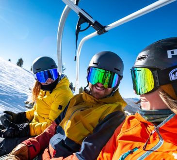 2 person in yellow jacket wearing helmet riding on cable car during daytime