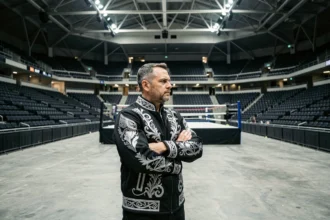 Catcheur professionnel seul dans une arène vide, symbolisant une décision de carrière majeure comme un départ de la WWE en 2026
