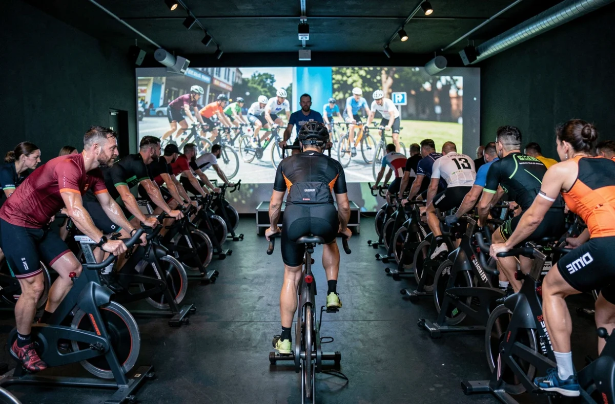 Cours de cycling collectif au Dynamo Cycling Bordeaux avec participants sur vélos stationnaires dans un studio immersif