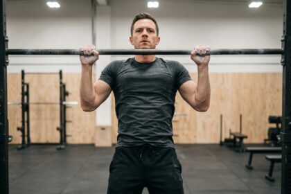 Homme musclé en train de faire un pull-up en salle de sport