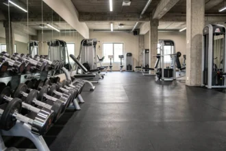 Vue panoramique d'une salle de musculation moderne dans le Rhône avec équipements chromés et miroirs