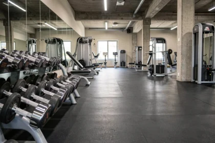 Vue panoramique d'une salle de musculation moderne dans le Rhône avec équipements chromés et miroirs